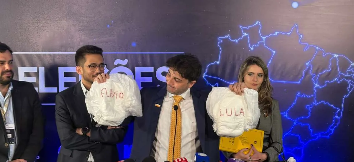 Renan Santos leva fralda com nomes de Lula e Flávio e critica ausência de dupla em debate da Band: "Dois fracassados"