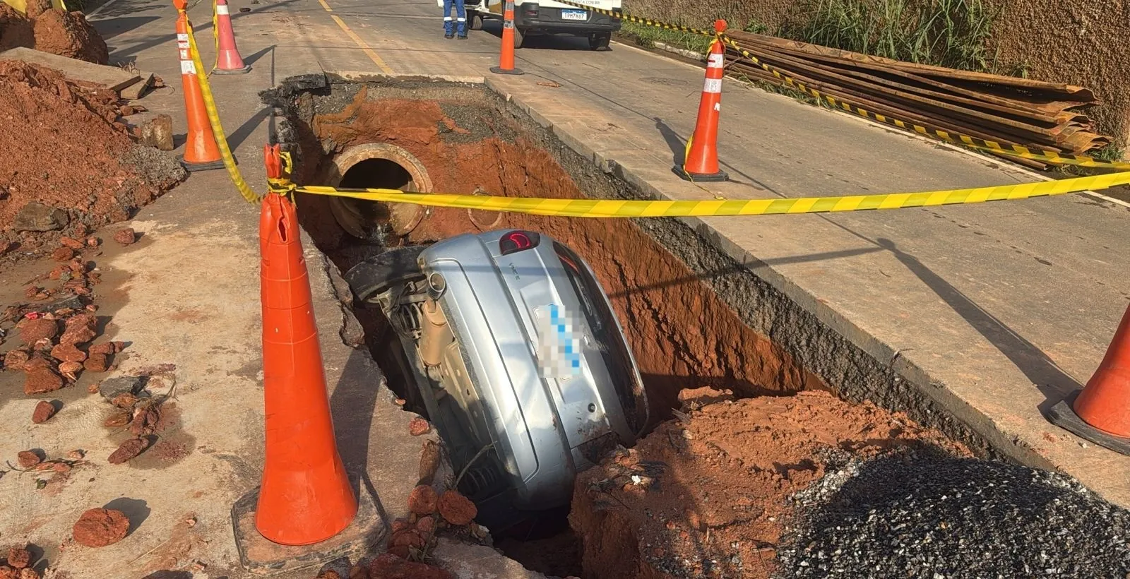 Carro cai em cratera de rua em obras em Juiz de Fora