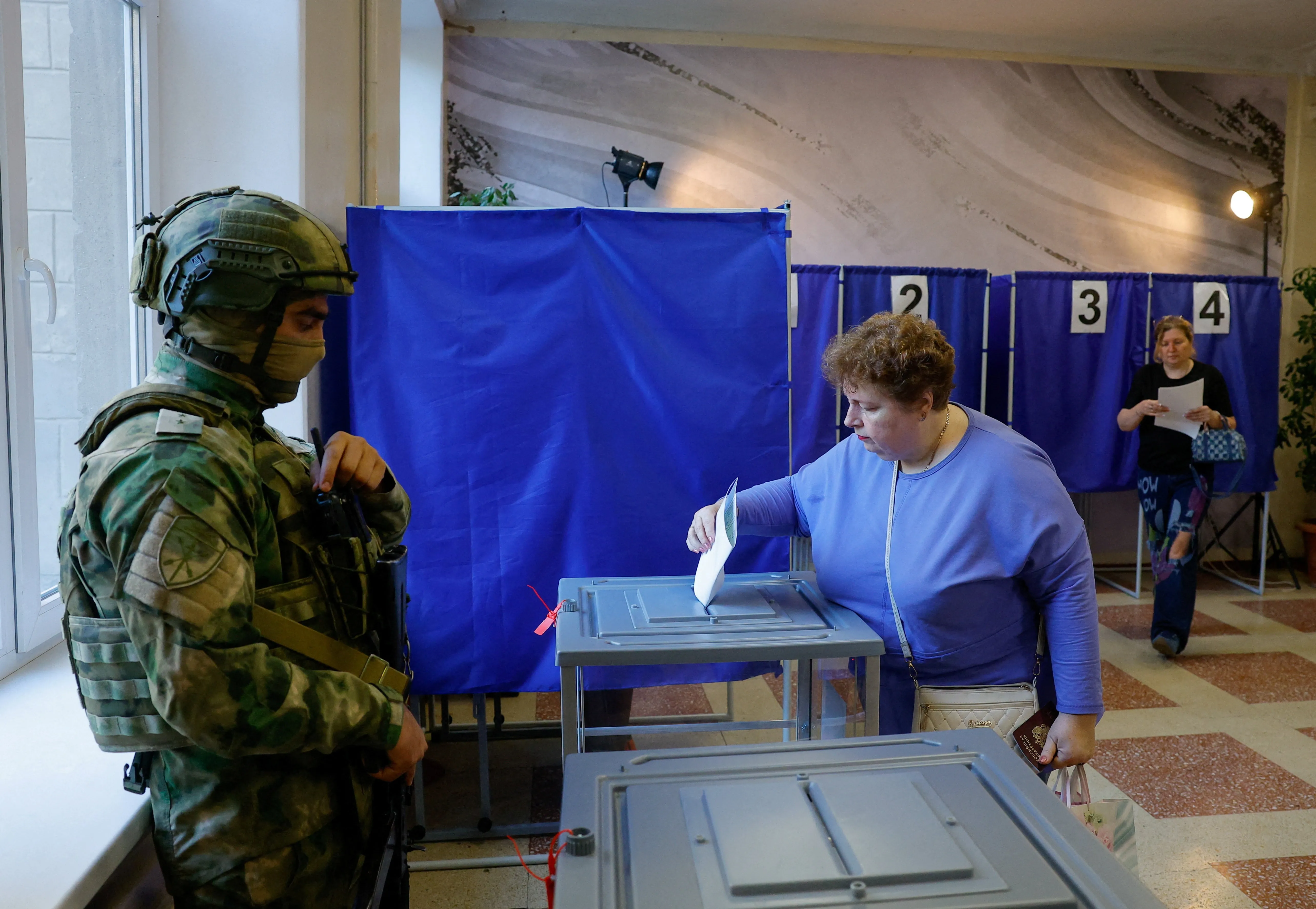 Vigiados por militares armados, ucranianos de região ocupada pela Rússia votam em eleição parlamentar russa; veja FOTOS